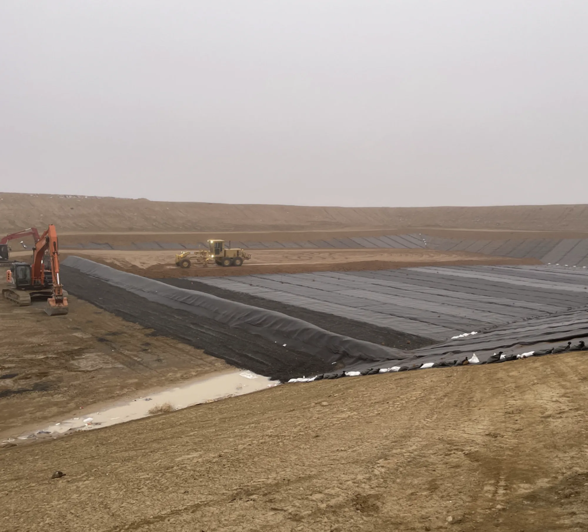 Containment liner installation at waste management site — geomembrane cell construction