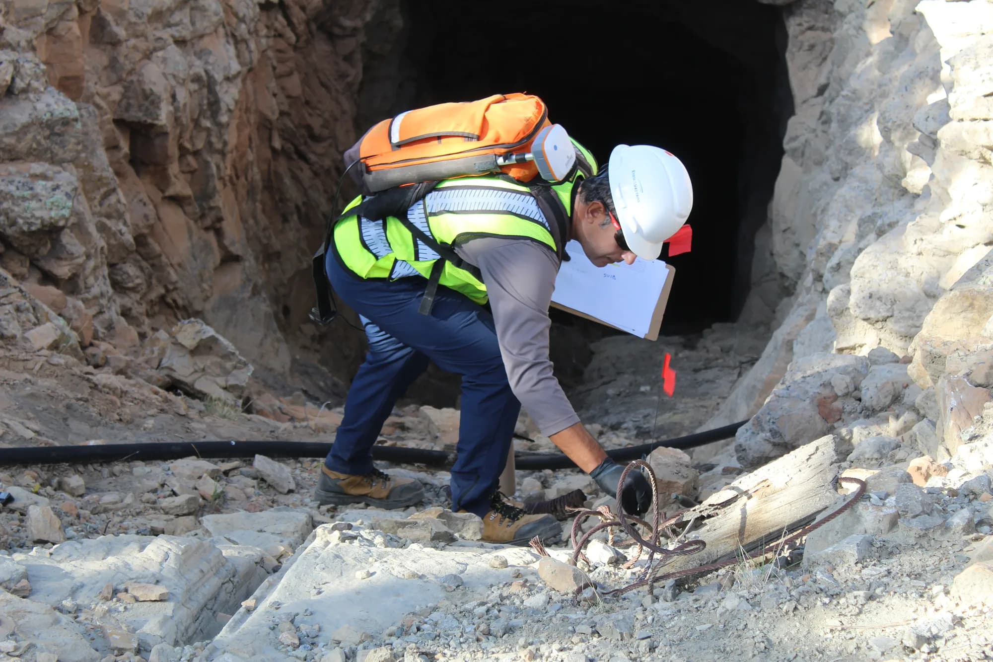 Field technician conducting radiological survey at a Schmitt Decline Mine portal — Grants Mining District, NM